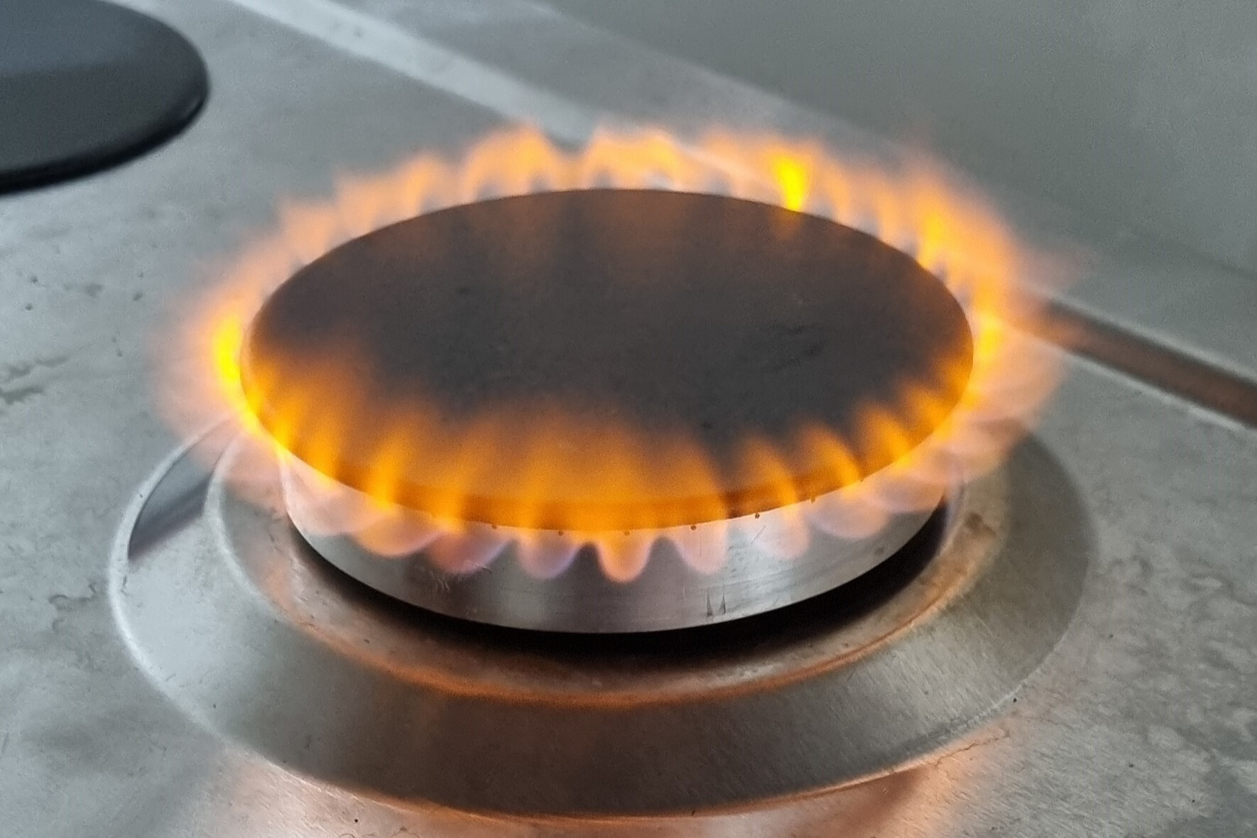 A stovetop with a flame on top