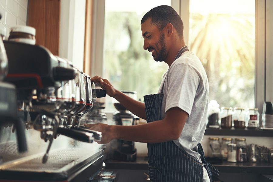 Male barista operating an espresso machine